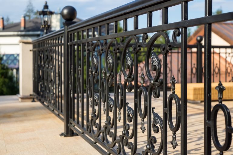 Ornamental black fence installation by Fortitude Fencing highlights the property's aesthetic appeal and security.