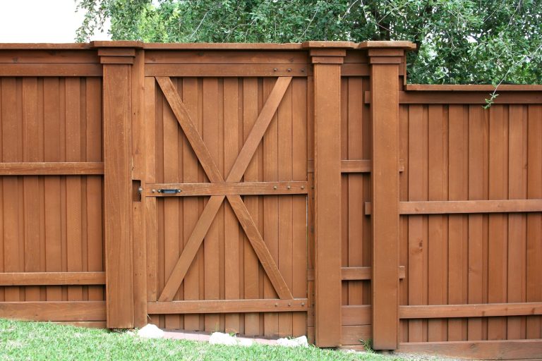 Rustic wooden gate by Fortitude Fencing enhances curb appeal and provides a welcoming entrance.